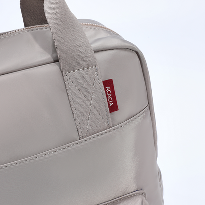 Close-up detail of the Reed Backpack showing reinforced top handles, premium stitching, metal hardware, and the signature ACACIA label. A stylish unisex backpack designed for durability and everyday use.
